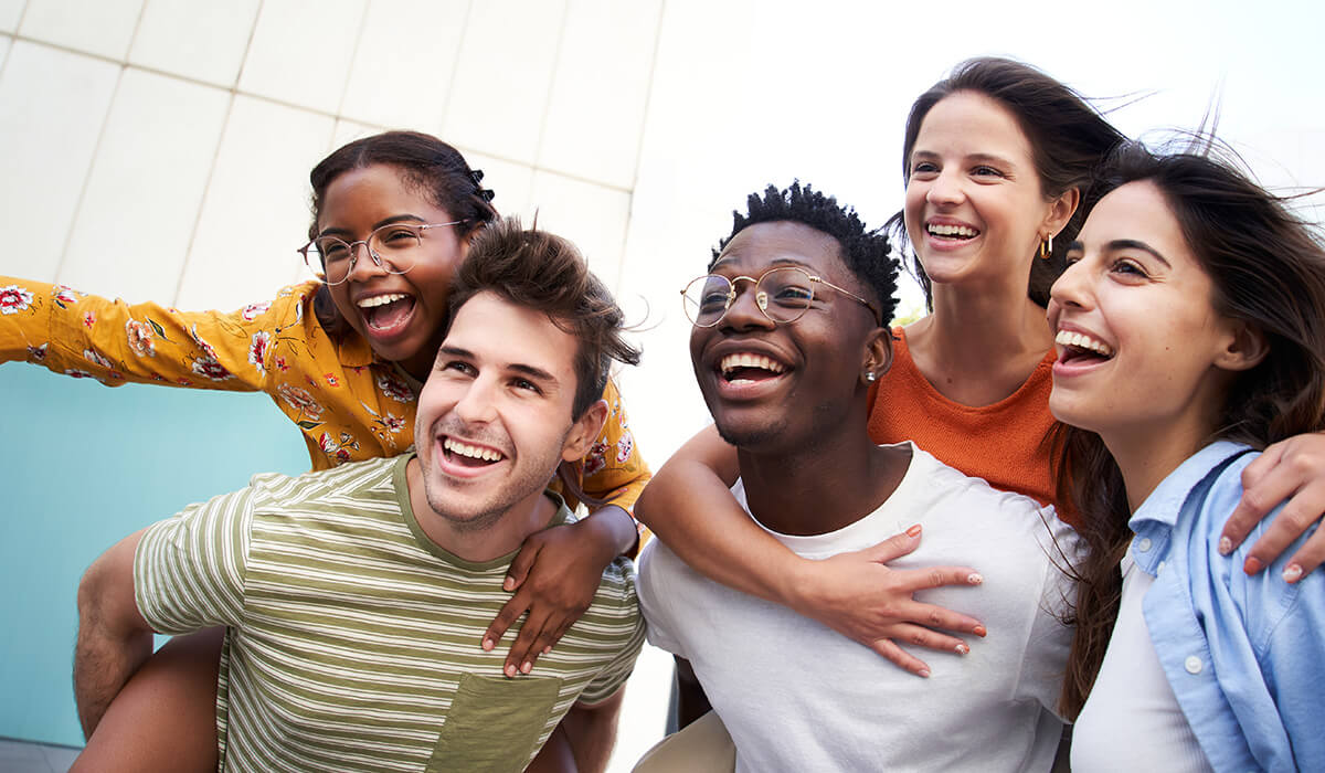 The image shows several people of different backgrounds laughing together.